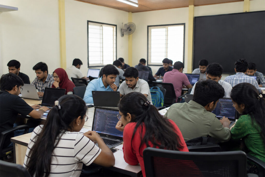 Students coding together on a real-life project at ScholarLogic