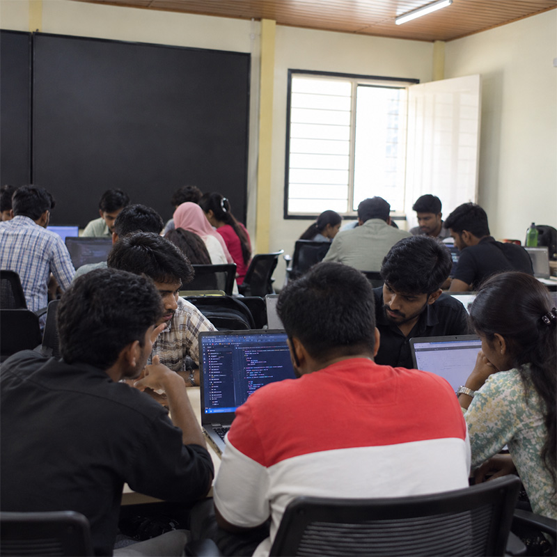 Students working together on a group coding project at ScholarLogic